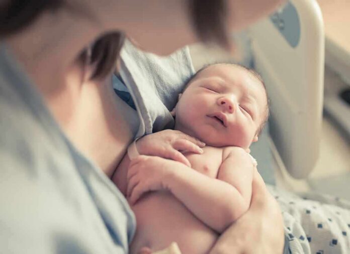 shutterstock_663728050-1 newborn baby sleeping in a parent's arms