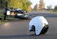 Motorbike Swarms Lock Down Iran White motorcycle helmet on road with fallen bike in background