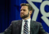 Vance Taunt Upends Crucial Michigan Race Man in suit with striped tie sitting on stage