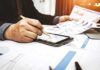 Pentagon Slams Brakes On War Bets Businessperson analyzing charts with tablet and papers