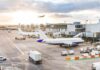 Passenger Joyride Shuts Down Gate Airplanes at airport gates during sunset with ground vehicles and jet bridges