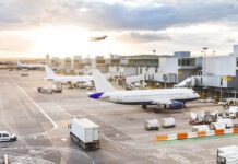 Passenger Joyride Shuts Down Gate Airplanes at airport gates during sunset with ground vehicles and jet bridges