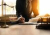 Justice System Misfires – Twice Lawyer writing at desk with scales and gavel