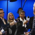 Access War Erupts – 14 Days Ticking Journalists interview a man in a suit with microphones