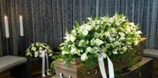 Coffin with white flower spray in a funeral setting