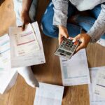 Heating-Oil Spike: 31% Budget Punch People sitting on floor calculating bills with a calculator
