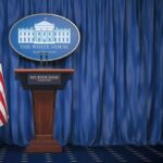 Trump Demands New Ukraine President White House press briefing podium with U.S. flag and blue curtain
