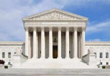 Pressure Campaign Hits High Court Front view of the Supreme Court building with large columns and steps under a blue sky