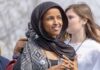 Feds Probe Rep. Ilhan Omar – What’s Hidden? Ilhan Omar wearing a black headscarf at an outdoor event