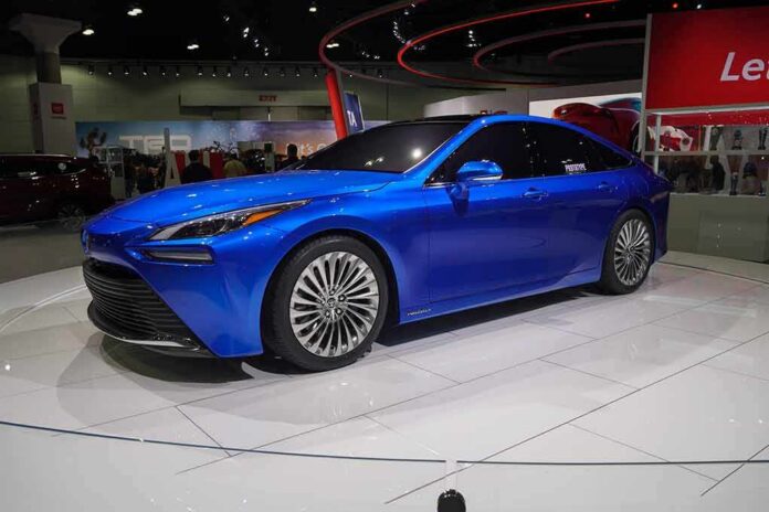 shutterstock_1574761108 Blue sedan on display at an auto show