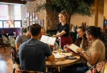 Lawmakers Backpedal – Why Tips Suddenly Matter Server taking orders from a group at a restaurant table