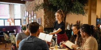 Server taking orders from a group at a restaurant table
