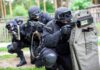 Tactical team advancing with ballistic shield and rifles