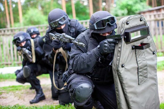 shutterstock_1841092291-1 Tactical team advancing with ballistic shield and rifles