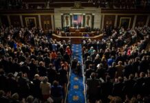 National Security Shock Hits Michigan Legislative chamber audience stands and applauds