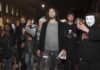 Prosecutors Paint Russell Brand as Serial Predator Russell Brand walking with a crowd at night